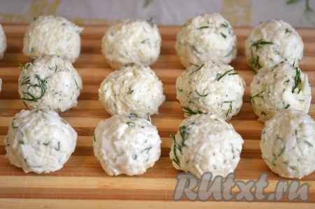 Из получившейся сырной массы влажными руками скатать небольшие шарики. Если вы готовите их часа за 3-4 до подачи, то в таком виде отправьте их в холодильник.