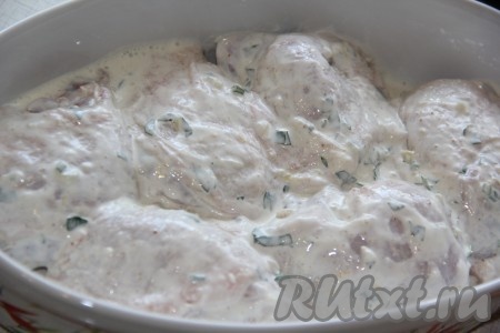 Я готовила мясо в керамической форме, но можно использовать противень с высокими бортиками. Выложить куриные бёдра вместе со сметаной с чесноком в форму в один слой. Духовку заранее разогреть. Поставить форму с курицей в духовку и запекать при температуре 180 градусов минут 50 минут (до золотистой корочки).