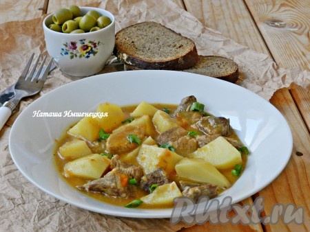 Вкусную, сочную тушёную свинину с мягкими кусочками картошки переложить со сковороды на тарелки и подать к столу.