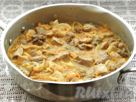 Влить в сковороду горячую воду так, чтобы она полностью покрыла свинину, перемешать, довести до кипения и тушить на медленном огне под крышкой 20 минут.