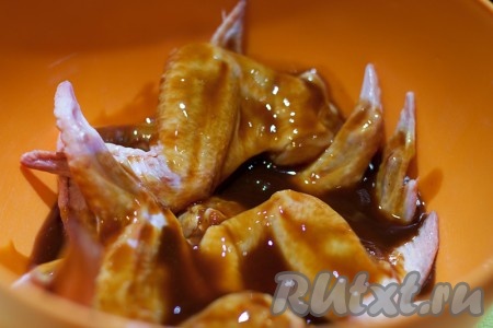 Замаринуйте куриные крылья минут на 10-15 в смеси кетчупа и соевого соуса.
