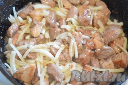 Затем добавить лук, перемешать, обжарить немного, помешивая.