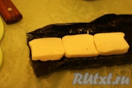 Лист нори слегка смочить водой, выложить сыр.