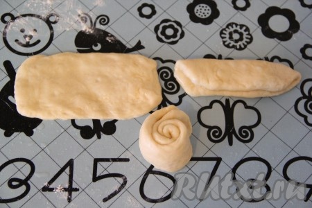 Разделить тесто на 18-20 частей. Размер булочек можно сделать по вашему  желанию, у меня получились небольшие. Раскатать тесто в овал, слегка смазать растительным маслом. Сложить овал пополам и свернуть в тугой рулетик.