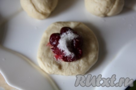 На тесто выложите вишню и присыпьте ее сахаром.