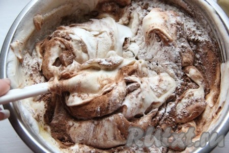 Частями добавьте просеянную муку и какао, аккуратно смешивая их с яичной массой с помощью лопатки движениями "снизу вверх".