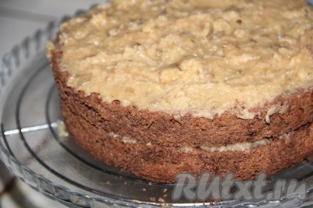 Бисквит разрежьте на три коржа. На плоскую тарелку выложите первый корж, смажьте половиной крема, накройте вторым коржом, смажьте оставшимся карамельным кремом и накройте третьим коржом.