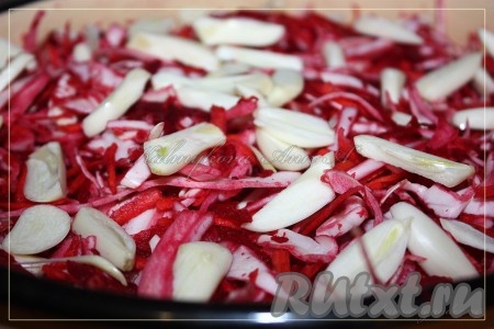 Уложить в кастрюлю, лучше объемом 5 литров. Чеснок порезать и положить сверху.
