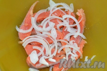 Выкладываем в пластиковую миску первый слой горбуши, посыпаем смесью соли и сахара, засыпаем слоем нарезанного полукольцами лука.