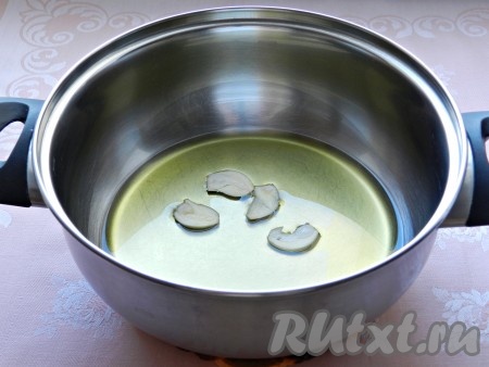В небольшую кастрюльку влить растительное масло, выложить нарезанный чеснок, поставить на средний огонь и обжарить 1 минуту.