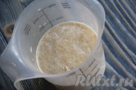 Молоко подогреть на плите (или в микроволновке) до температуры 38-40 градусов, перелить в объёмную чашу, всыпать дрожжи, тщательно перемешать и оставить в тёплом месте на 15 минут, для того чтобы дрожжи ожили. По истечении времени вся поверхность дрожжевой смеси покроется пузырьками. 