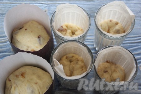 Куличи я выпекала в бумажных формах и в стаканах из толстого стекла. Внутреннюю поверхность стакана я выложила пергаментной бумагой. Разложить тесто по формам, заполняя их на 1/2 объёма.