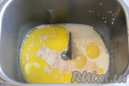 В ведёрко хлебопечки влить запенившуюся дрожжевую смесь, добавить желтки, растительное масло и растопленное негорячее сливочное масло.