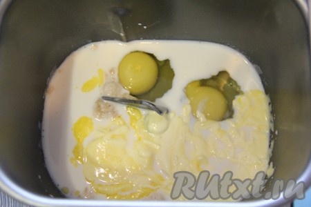 В ведёрко хлебопечки влить молоко с дрожжами, добавить яйца и растопленное масло.