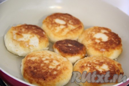 Как только выложили сырники, сделать огонь средним. Жарить сырники до золотистой корочки (примерно 3-4 минуты), потом перевернуть на другую сторону и продолжить жарить тоже до золотистости (примерно 2-3 минуты). Затем выключить огонь, накрыть сковороду крышкой и дать сырникам дойти ещё в течение 3-4 минут.