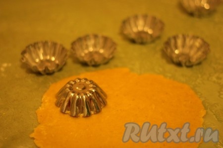 Железные формочки для кексов смазать сливочным маслом. Вырезать из теста кусочки нужного размера для тарталеток.
