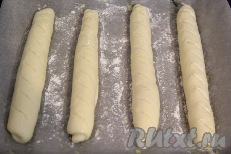 Сделать на поверхности багетов неглубокие надрезы (я надрезы сделала лезвием). Поставить противень в духовку, разогретую до 180 градусов, выпекать французские багеты минут 15-20 (до золотистости дрожжевого теста). Затем вынуть и остудить на решётке.