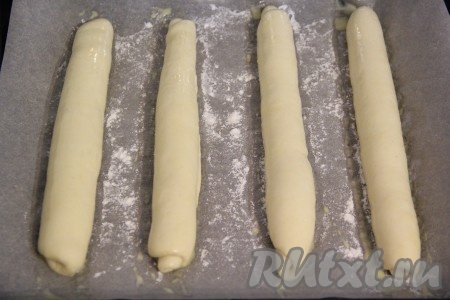 Прикрыть противень полотенцем и оставить на 30 минут в тёплом месте. Когда багеты поднимутся, слегка смазать их взбитым желтком, смешанным с 1 чайной ложкой молока.