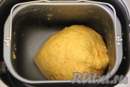 По сигналу добавить натёртую морковь в ведёрко хлебопечки. В процессе замешивание теста важно контролировать формирование колобка, если тесто будет сильно липнуть к стенкам хлебопечки, тогда нужно будет добавить немного муки, чтобы тесто стало нужной консистенции. Если делать замес вручную, тогда в достаточно объёмную миску нужно влить тёплую воду (температура воды должна быть 38-40 градусов), всыпать сахар, дрожжи, тщательно перемешать и оставить минут на 10-15 (до появления пенной шапочки на поверхности смеси), затем добавить соль, растопленное не горячее масло и яйцо, слегка перемешать. Всыпать частями просеянную муку, перемешивая тесто сначала ложкой, а затем тщательно вымесить его руками. Добавляя муку, учитывайте, что тесто для хлеба должно получиться эластичным и мягким, к рукам оно липнуть не должно. Затем добавить морковку, натёртую на мелкой тёрке, и вмешать её в тесто. Оставить тесто в миске, накрыв полотенцем, и поставить в тепло на 1-1,5 часа для подъёма (до увеличения в объёме минимум в 2 раза).