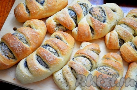 Готовые дрожжевые рогалики с маком снять с пергамента, переложить на доску, накрыть полотенцем и оставить остывать. Пока выпечка остывает, можно готовить стол к чаепитию.