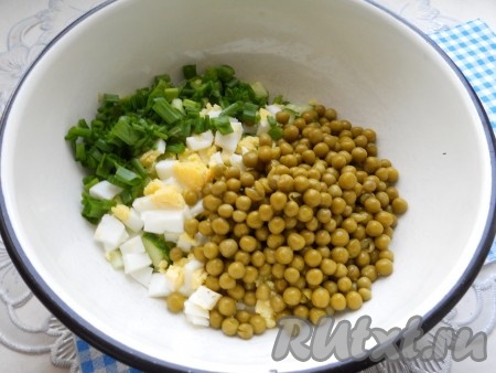 Горошек отцедить от рассола и добавить в салат вместе с измельченной зеленью.
