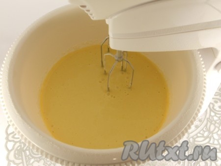 К взбитым яйцам влить растительное масло, молоко, взбить миксером на небольшой скорости до однородности. Всыпать разрыхлитель, частями начать добавлять просеянную муку, перемешивая тесто миксером на небольшой скорости.