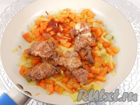 Обжарить лук и морковь на небольшом огне, периодически помешивая, в течение 8-10 минут, после чего добавить томатную пасту и тушенку с жидкостью (жир убрать).
