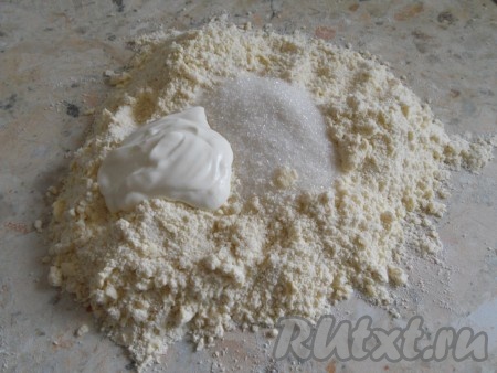 Хорошо растереть муку с маслом руками до образования мелкой, однородной крошки. Сделать снова небольшое углубление, куда добавить соль, сахар и холодную сметану. 