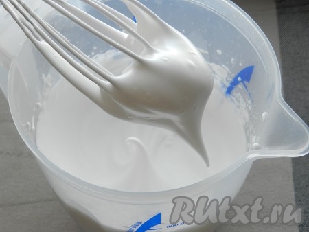 Постепенно (по одной столовой ложке) всыпать сахарную пудру, продолжая активно взбивать после каждой ложки. Взбивать до тех пор, пока масса не взобьётся до устойчивых пиков, как для традиционного безе.