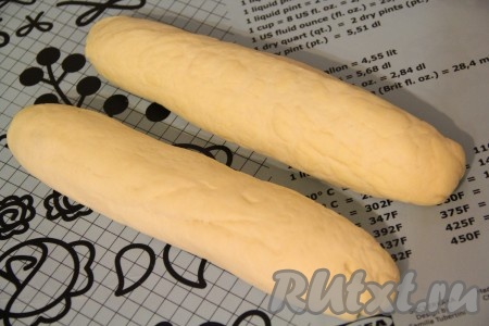 Разделить тесто на 2 части. Размеры батонов вы можете определить сами, можно сделать 4 батона меньшего размера или, как я, - 2 батона. Из каждой части теста сформировать колбаски (у меня получилось 2 заготовки батонов).