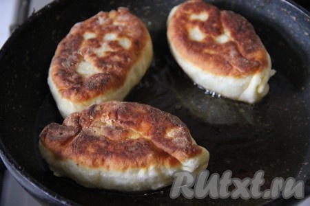 Края пирожка слепить. На сковороде разогреть растительное масло. Выложить партию пирожков на сковороду швом вниз. Жарить с двух сторон до золотистого цвета на среднем огне. Аналогично пожарить все пирожки.