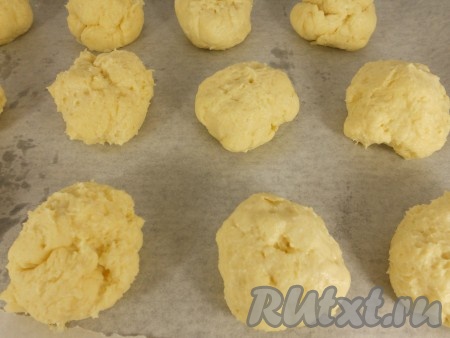 Разделить тесто на 15-17 кусочков. Чуть смачивая руки в воде, скатать шарики (слишком гладкие и ровные делать не старайтесь, просто скатайте комочки). Выложить комочки теста на противень, застеленный пергаментом, на расстоянии 4-5 см друг от друга.
