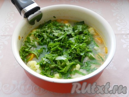 Шпинат промыть, нарезать на полоски. Выложить в куриный суп шпинат, довести до кипения и готовить еще 2-3 минуты.
