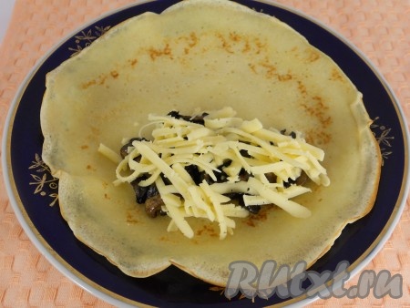 На край каждого блина выкладывать по 1-2 столовых ложки грибов, сверху - 1 столовую ложку натёртого на крупной тёрке сыра. Подвернуть края блина на начинку с двух сторон, а затем свернуть блинчик рулетиком, начиная со стороны с начинкой.