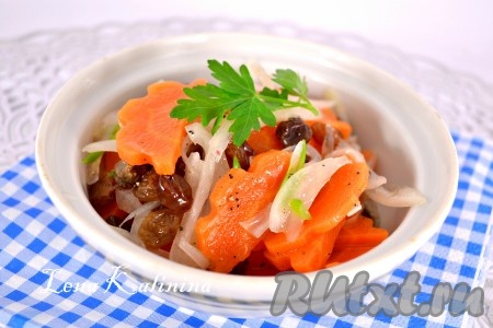 Выложить очень вкусный салат из моркови с изюмом в салатник, украсить веточкой зелени и подать к столу.