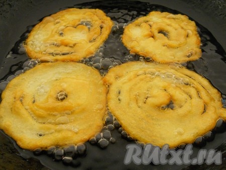 Далее тесто вылить в целлофановый пакет, сделав небольшую дырочку в уголке (или в кондитерский мешок). Растительное хорошо разогреть в глубокой сковороде (или в кастрюле). Выдавливать тесто в кипящее масло тонкой струйкой в виде спиралей. Жарить на небольшом огне с двух сторон до румяности. Жарятся джалеби быстро - по 1-2 минуты с каждой стороны.