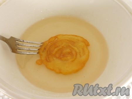 Горячие "спиральки" сразу же помещать в сироп секунд на 10 (при длительной пропитке джалеби потеряют хрусткость), после чего переложить на решётку, чтобы лишний сироп стёк.