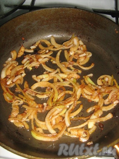 В это время подготовить картофель: почистить, нарезать и поварить минут 5-10 в соленой воде. Готовое мясо убрать с противня и в этот противень выложить картофель. Посыпать его приправой и полить чесночным маслом, перемешать и отправить в духовку до готовности. Репчатый лук нарезать полукольцами и обжарить в сковородке, в которой жарилось мясо.
