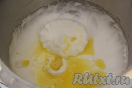 Сливочное масло растопить и слегка остудить. Добавить растопленное масло к взбитым белкам и перемешать на низкой скорости миксера, вмешивая масло.