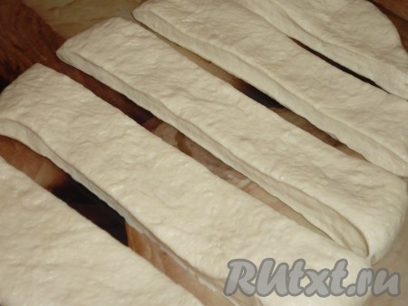 Поднявшееся тесто раскатать в пласт и нарезать полосками.
