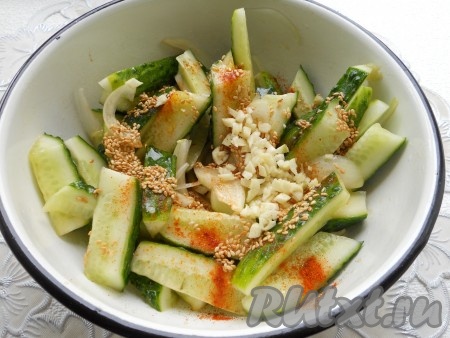 Добавить обжаренный кунжут вместе с маслом в китайский салат из огурцов. Также добавить измельченный чеснок. По вкусу досолить (если понадобится). Хорошенько все перемешать.
