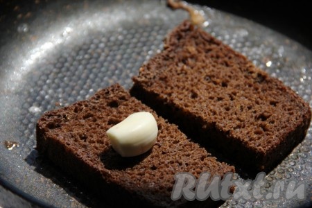 Черный хлеб для бутербродов нарезать тонкими ломтиками, обжарить на сковороде с оливковым маслом. Поджаренный хлеб натереть чесноком и присыпать крупной солью.
