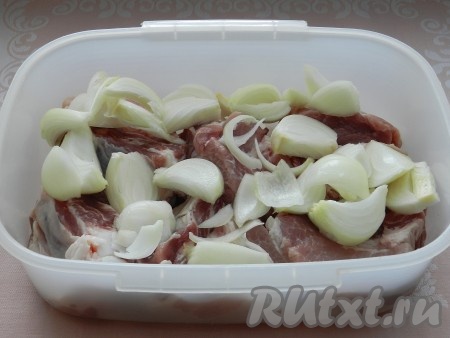 Лук очистить, нарезать крупно и добавить к свиным рёбрышкам.