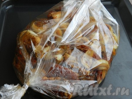 Затем переложить свиные рёбрышки вместе с луком и соево-медовым соусом в рукав для запекания, завязать рукав с двух сторон, переложить на противень и поставить в разогретую до 190 градусов духовку на 1 час.