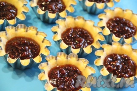 Выложить начинку (у меня варенье) в корзиночки из песочного теста, заполняя на 1/3 объёма.