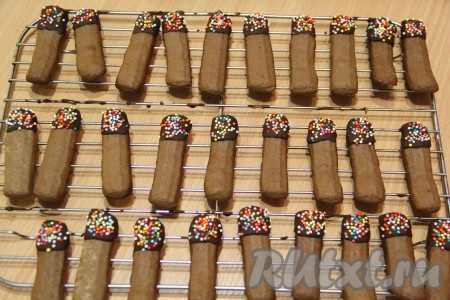 Поставить противень с печеньем, замешанным на яичных белках, в разогретую духовку и выпекать минут 15 (до лёгкого золотистого цвета) при температуре 180 градусов. Готовое печенье остудить и можно кушать. Я решила украсить печенье, для этого нужно растопить шоколад, окунуть печенье в шоколад, а затем посыпать цветной посыпкой и оставить на решётке до застывания шоколада.