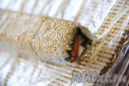 Готовый ролл с кунжутом выложить на плоскую тарелку и дать ему немного отдохнуть.
