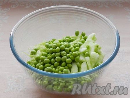 Соединить свежую капусту, огурцы и зелёный горошек в миске.