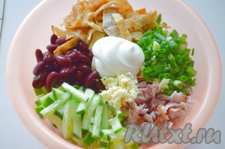 В миску выкладываем фасоль без жидкости, копчёную курицу, яичные блинчики, огурец, нарезанный лук, пропущенный через пресс чеснок, солим, перчим, заправляем сметаной или майонезом.