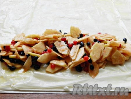 Всыпать к яблокам крахмал и сахар. Я ещё добавила немного свежих ягод, но это по желанию. Перемешать яблоки с крахмалом, ягодами и сахаром до однородности. Всего я сформировала 3 рулета, то есть для формирования каждого рулета я взяла 4 листа тесто фило. Поэтому и начинку разделила на 3 равных части. Выложить на тесто 1/3 яблочной начинки ближе к одному из краёв теста, оставляя при этом края теста чистыми. Благодаря крахмалу, сок, выделяющийся из яблок в процессе выпечки, будет желироваться, поэтому рулет из теста фило не размокнет. 